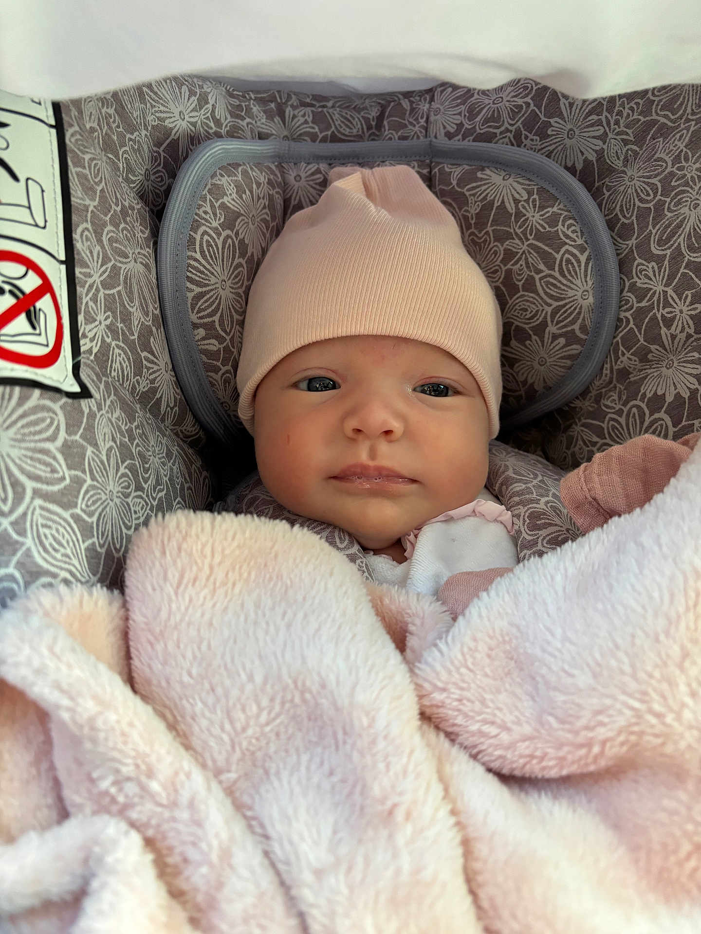 Capucine participe au concours pour gagner de l'argent avec cette photo : baby, infant, blanket, hat, face, eyes, person, child, carseat, pattern, pink, soft, cozy, cute, newborn, portrait, wrapped, warm, indoors, resting