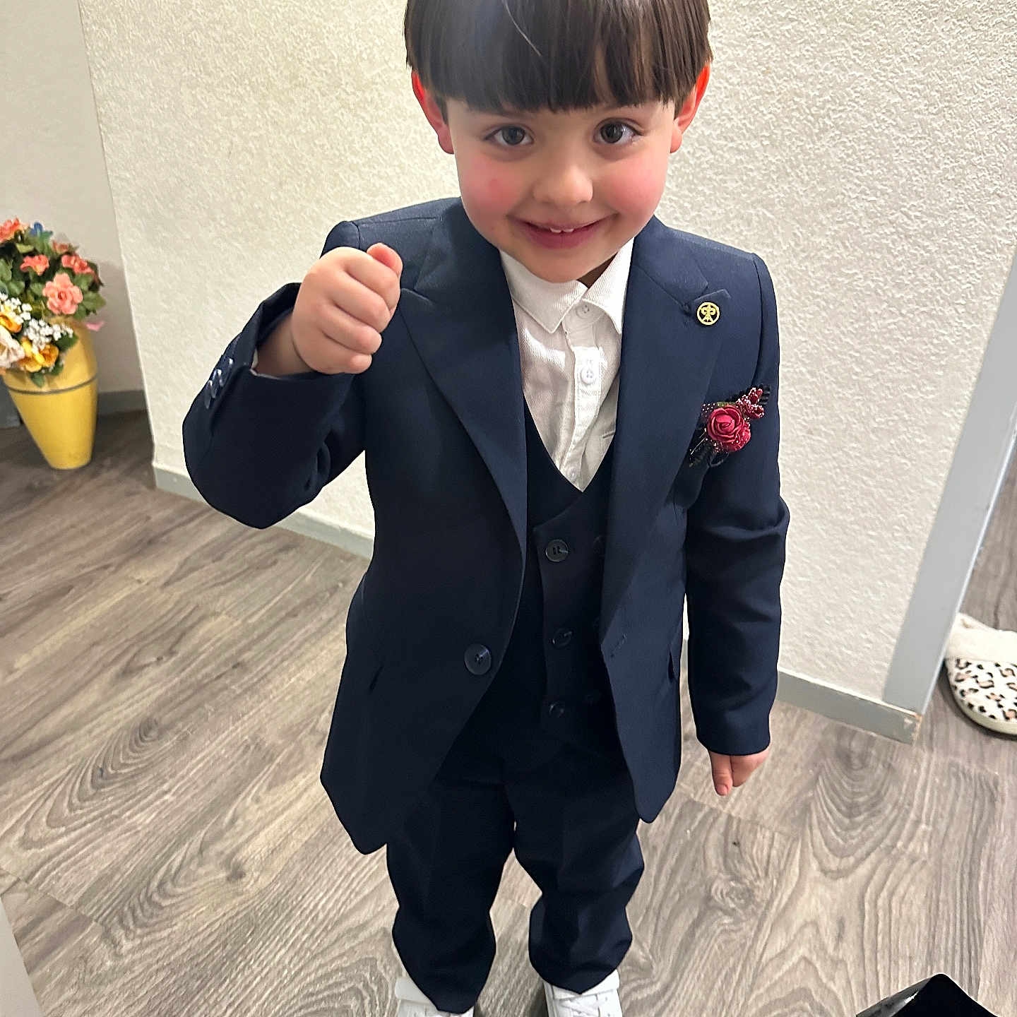 Amir El Ouadani participe au concours pour gagner de l'argent avec cette photo : child, boy, suit, indoor, smile, white_shoes, wooden_floor, flower_vase, boutonniere, confident, gesture, portrait, happy, flooring, wall, footwear, standing, closeup, casual, home