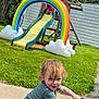 Dennis joined the competition — help win amazing prizes! child, toddler, toy_car, slide, rainbow, playground, outdoor, grass, sidewalk, summer, happy, smiling, person, play, fun, greenery, tree, wooden_structure, clothing, park