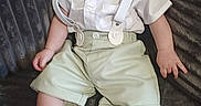 Oliver joined the competition — help win amazing prizes! baby, child, smile, suspenders, bow_tie, shorts, shirt, sitting, couch, gray, texture, happy, cute, infant, portrait, indoor, young, person, feet, legs