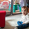 Oliver joined the competition — help win amazing prizes! toddler, child, sitting, carpet, indoor, toy, playpen, red_chair, jeans, white_shirt, smiling, face, person, home, floor, play_area, cute, baby, childhood, cozy