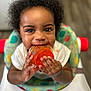 toddler, child, baby_food, high_chair, curly_hair, smiling, messy, orange_food, cute, hands, face, indoor, person, infant, feeding, happy, closeup, seat, playful, young