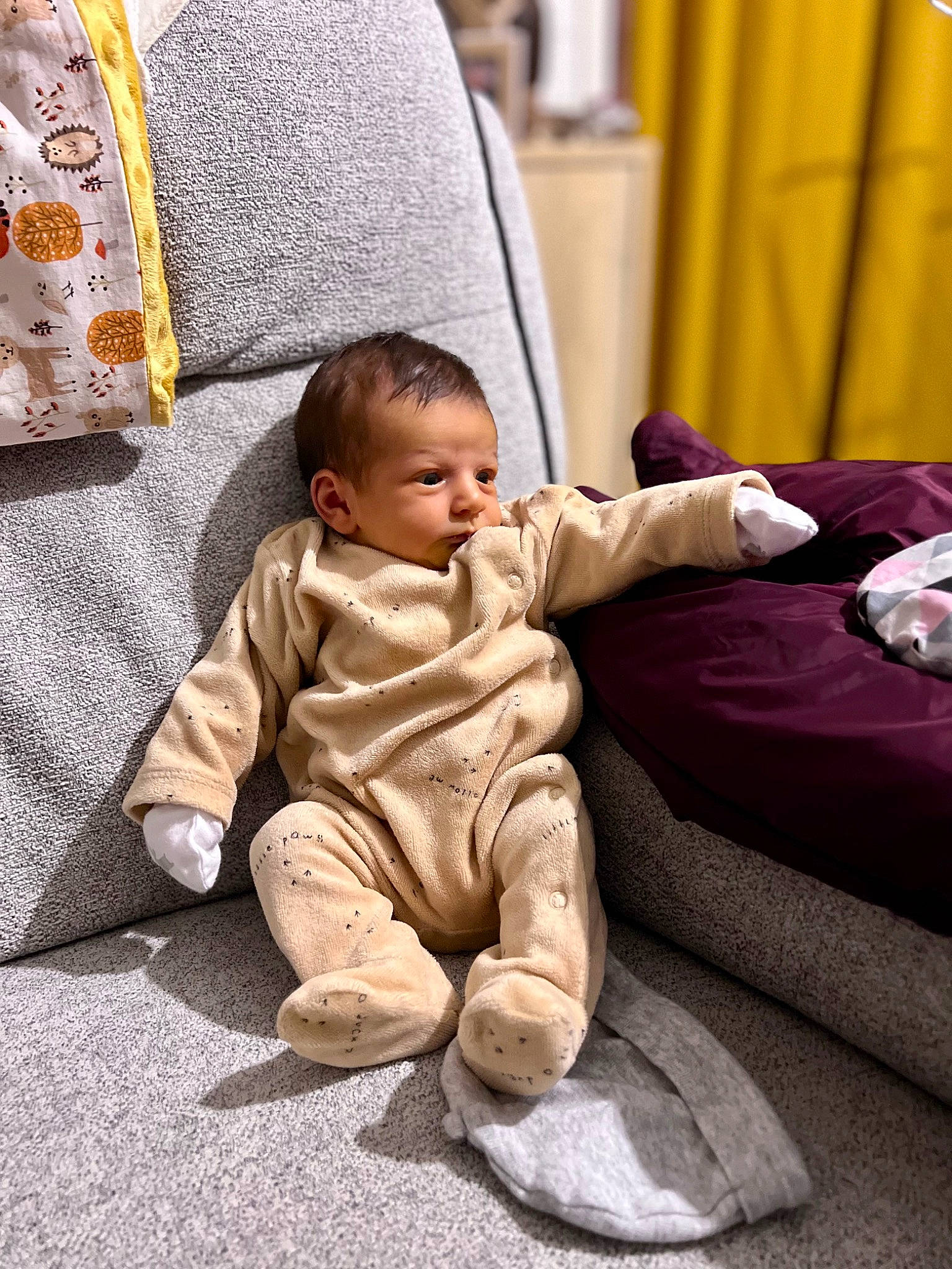 Alyah a rejoint le concours — aidez-le/la à gagner de superbes lots ! baby, baby_toddler_clothing, cheek, child, comfort, couch, curtain, floor, flooring, foot, head, linens, living_room, person, room, sitting, textile, throw_pillow, toddler, watch