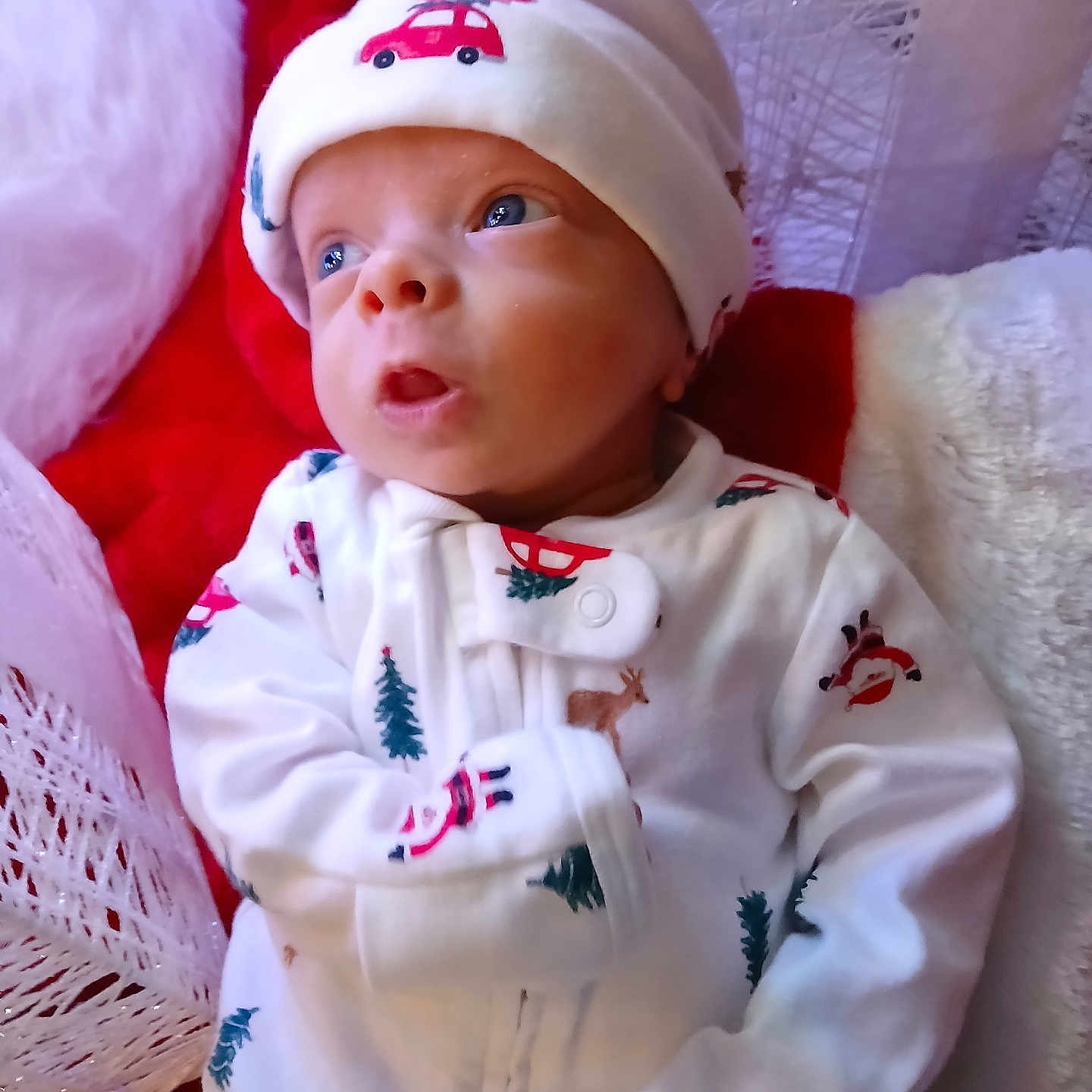 Paxton is registered to the contest to win money with this photo: baby, blanket, blue_eyes, child, christmas, cozy, cute, expression, face, hat, holiday, indoors, infant, newborn, pajamas, person, portrait, red, soft_texture, white