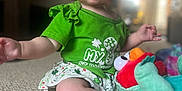 Azura is registered to the contest to win money with this photo: toddler, child, green_clothing, headband, plush_toy, carpet, indoor, rosy_cheeks, curious_expression, sitting, soft_background, light, person, baby, toy, short_sleeves, skirt, footwear, cute, holiday_theme