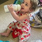 Azura joined the competition — help win amazing prizes! baby_bottle, blanket, carpet, casual, child, curly_hair, cute, floor, happy, indoor, milk, person, playtime, red_purse, sitting, smiling, strawberry_dress, toddler, toy_castle, young_child