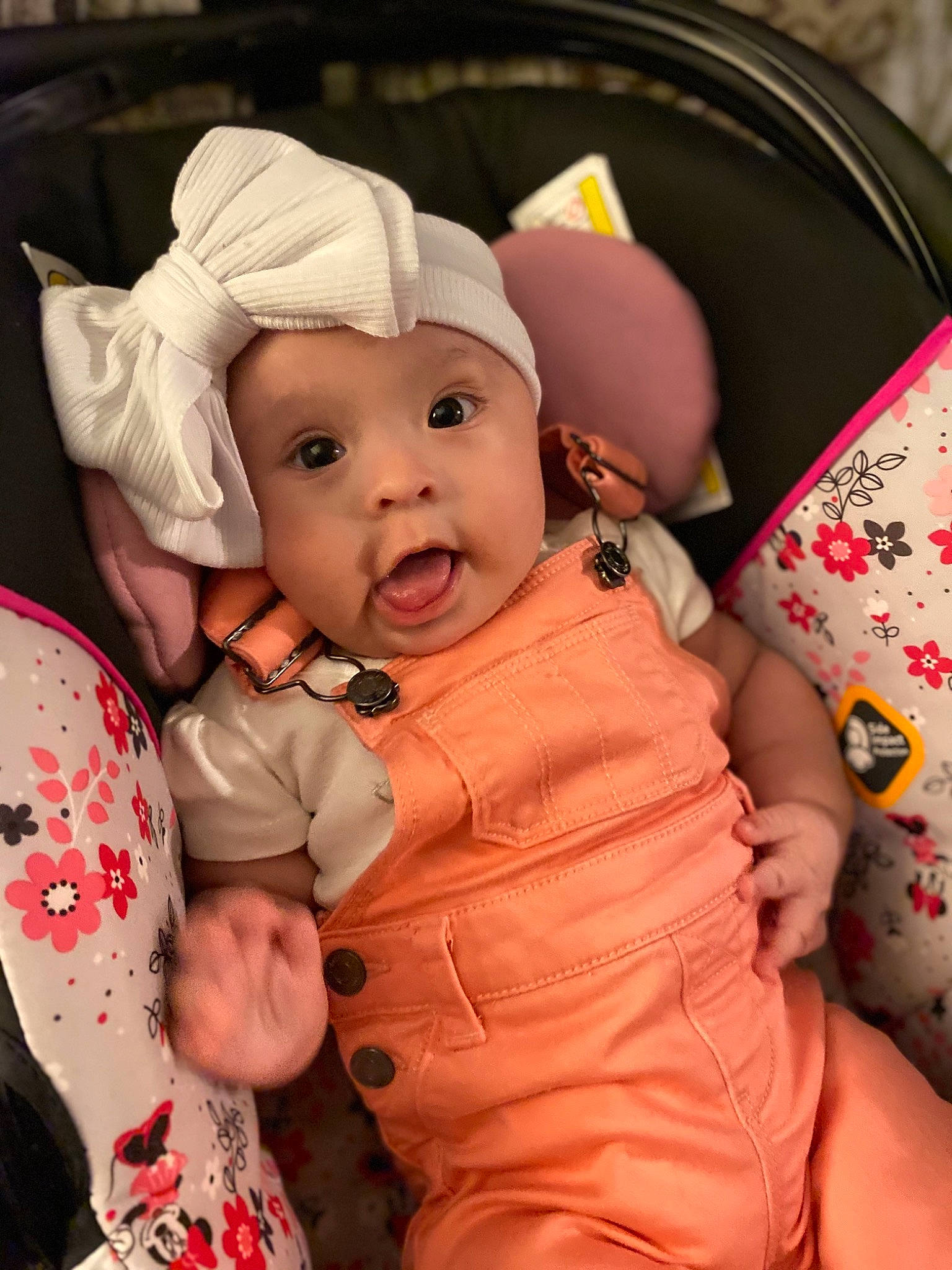 Khloe joined the competition — help win amazing prizes! baby, baby_products, baby_toddler_clothing, cap, cheek, child, comfort, fashion_accessory, finger, gesture, happy, headwear, mammal, mouth, person, pink, sitting, skin, sleeve, surprise