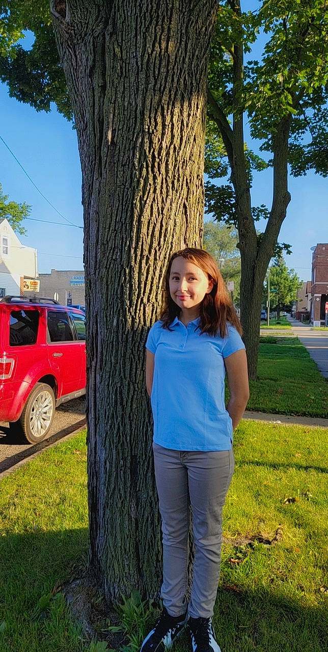 Alyssandra is registered to the contest to win money with this photo: automotive_exterior, automotive_tire, car, grass, green, joy, leisure, motor_vehicle, people_in_nature, person, photograph, plant, sky, standing, tire, tree, trunk, vehicle_door, waist, wheel