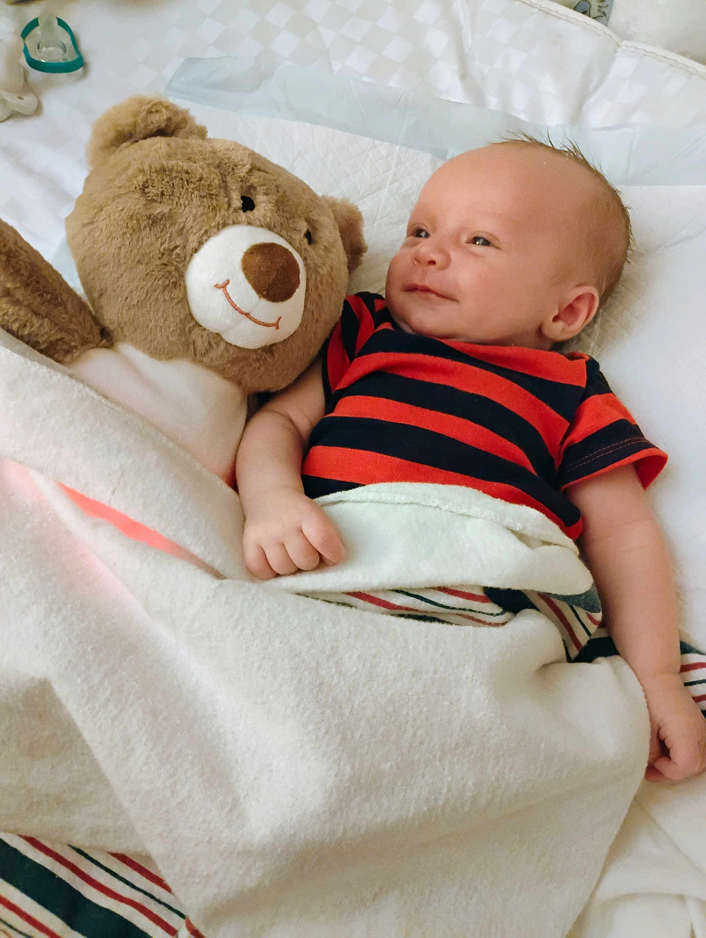 Lucian joined the competition — help win amazing prizes! baby, teddy_bear, blanket, smile, bed, infant, plush_toy, striped_clothing, cute, sleeping_area, comfort, child, soft_toy, happy, resting, indoors, cozy, lying_down, skin, head