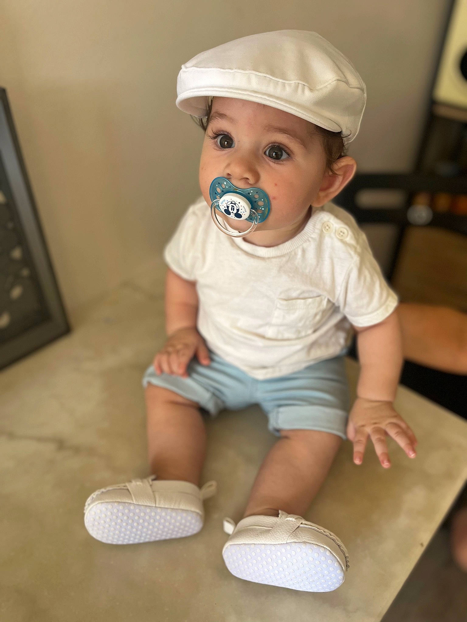 Juan a rejoint le concours — aidez-le/la à gagner de superbes lots ! baby, baby_toddler_clothing, cap, child, face, fashion_accessory, flooring, foot, fun, headwear, pattern, person, personal_protective_equipment, room, shorts, sitting, sleeve, t_shirt, toddler