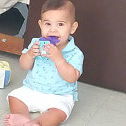 Rafael a rejoint le concours — aidez-le/la à gagner de superbes lots ! baby, child, toy, floor, sitting, blue_shirt, white_shorts, chewing, cute, indoor, play, colorful_toy, infant, feet, hands, smile, person, young_child, background, home