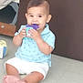 baby, child, toy, floor, sitting, blue_shirt, white_shorts, chewing, cute, indoor, play, colorful_toy, infant, feet, hands, smile, person, young_child, background, home