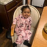 black_socks, chair, child, cozy, curly_hair, cute, granite_countertop, happy, indoor, kitchen, minnie_mouse, pajamas, person, pink, seat, smiling, table, toddler, wooden_cabinet, wooden_floor