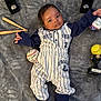 baby, infant, baseball_outfit, pinstripes, blanket, baseball, softball, mini_bats, rings, trophy, sports_memorabilia, cute, portrait, indoor, child, feet, hand, face, clothing, person