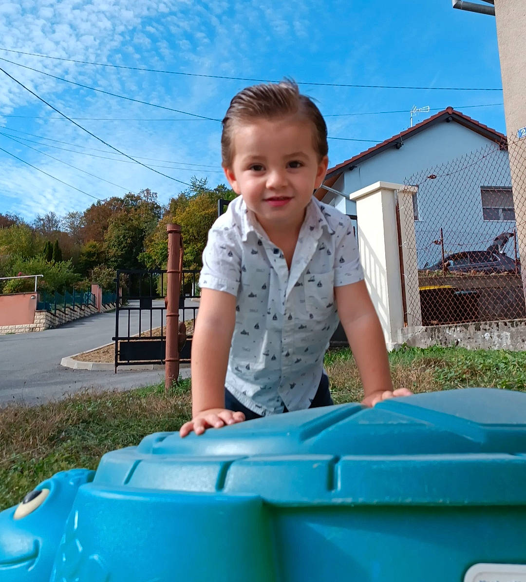 Anthonin a rejoint le concours — aidez-le/la à gagner de superbes lots ! blue, child, chute, city, cloud, electric_blue, fun, grass, happy, joy, leisure, outdoor_play_equipment, person, photograph, plant, recreation, sitting, sky, smile, t_shirt