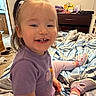 Blakely joined the competition — help win amazing prizes! bed, blanket, carpet, casual, child, dresser, furniture, hair, happy, indoor, person, pink_legwear, pony_tail, portrait, purple_shirt, room, smile, sneakers, television, toddler