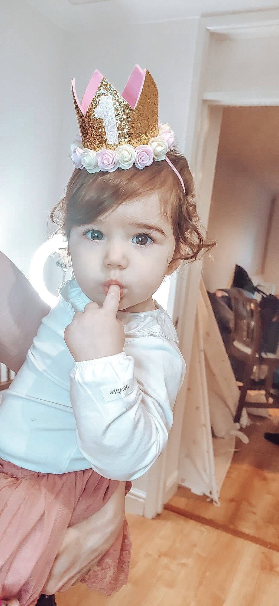 Leyla is registered to the contest to win money with this photo: baby_toddler_clothing, bridal_accessory, child, costume_hat, dress, eye, eyebrow, eyelash, fashion_design, happy, head, headgear, headpiece, iris, person, pink, skin, sleeve, textile, tiara