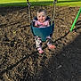 Lakelynn is registered to the contest to win money with this photo: baby, child, swing, playground, outdoor, grass, woodchips, sunlight, pink_clothing, camouflage, feet, face, happy, seat, metal_chains, park, young, person, daylight, nature