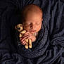 newborn, baby, teddy_bear, blanket, sleeping, knitted, soft_texture, peaceful, infant, wrapped, cute, portrait, child, cuddly, adorable, resting, close_up, warm, hands, cozy