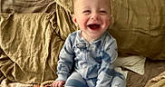 Cooper joined the competition — help win amazing prizes! baby, child, pajamas, bed, pillows, toy, crocodile_toy, pacifier, happy, smiling, indoor, cozy, cute, infant, person, playful, glowing_device, soft_furniture, home, relaxed