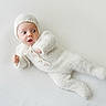 Bennett is registered to the contest to win money with this photo: baby, infant, knitted_outfit, bonnet, white, cozy, lying_down, wide_eyes, expression, texture, blanket, cute, small_hands, newborn, soft, portrait, child, warm_clothing, indoor, peaceful