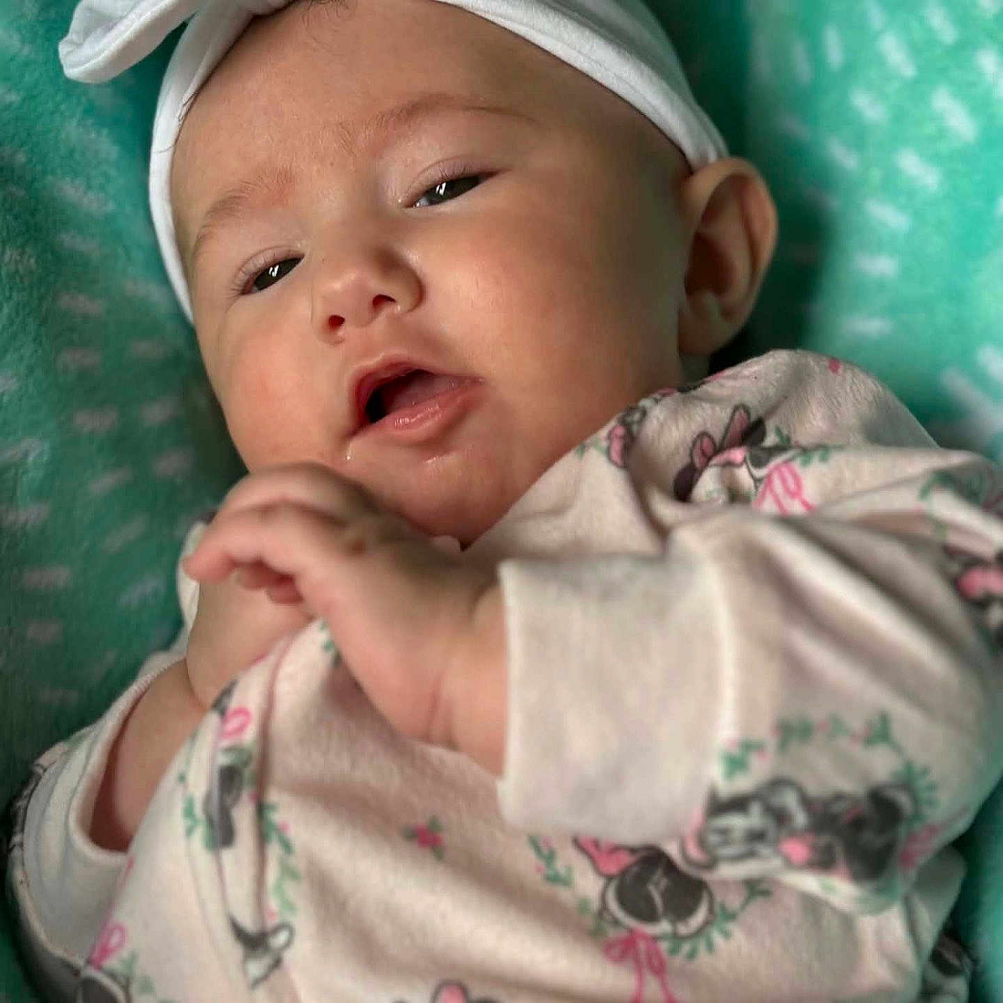 Mckinnleigh is registered to the contest to win money with this photo: baby, blanket, bow, child, closeup, clothing, cute, expression, face, hands, headband, indoor, infant, lying_down, minnie_mouse, onesie, portrait, sleepwear, soft, teal