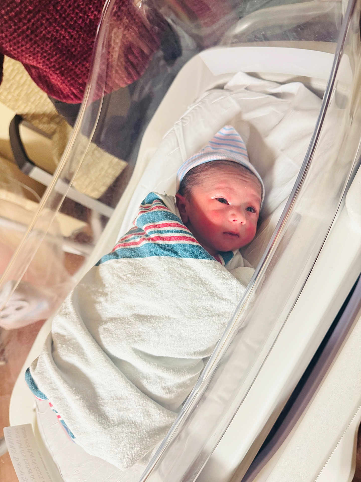 Faraj joined the competition — help win amazing prizes! newborn, baby, hospital, bassinet, swaddled, blanket, hat, infant, sleeping, bed, medical, patient, newborn_baby, crib, wrapped, person, face, cute, small, indoors