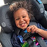 Malik is registered to the contest to win money with this photo: toddler, child, car_seat, smiling, happy, snack, curly_hair, seatbelt, indoors, casual_clothing, playful, portrait, child_safety, car_interior, young_child, cute, expression, person, seat, fun