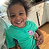 child, smile, happy, hair, green_shirt, cartoon, indoor, kitchen, cabinet, microwave, wood_floor, person, cute, portrait, toddler, holding_hand, casual_clothing, bright, young, joyful