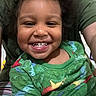 toddler, child, smile, happy, green_shirt, dinosaur_print, wild_hair, person, portrait, indoor, adult, family, cute, closeup, joyful, casual_clothing, young_child, expression, head_and_shoulders, playful
