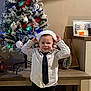 Milann a rejoint le concours — aidez-le/la à gagner de superbes lots ! child, boy, christmas_tree, santa_hat, holiday, decoration, indoor, smiling, tie, shirt, socks, floor, tile_floor, furniture, table, candle, picture_frame, festive, celebration, home