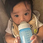 Julian joined the competition — help win amazing prizes! baby, bottle, bib, child, cute, drink, feeding, hand, infant, inside, person, portrait, sitting, smile, soft, toddler, warm, young, face, clothing