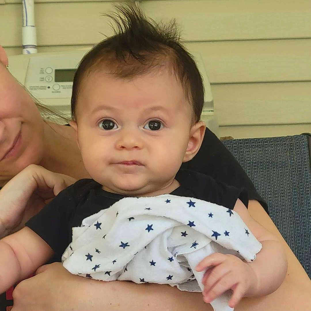 Kai joined the competition — help win amazing prizes! architecture, baby, blanket, building, clothing, door, face, happy, head, hospital, newborn, person, photography, portrait, quilt, selfie, shorts, sitting, smile, t_shirt