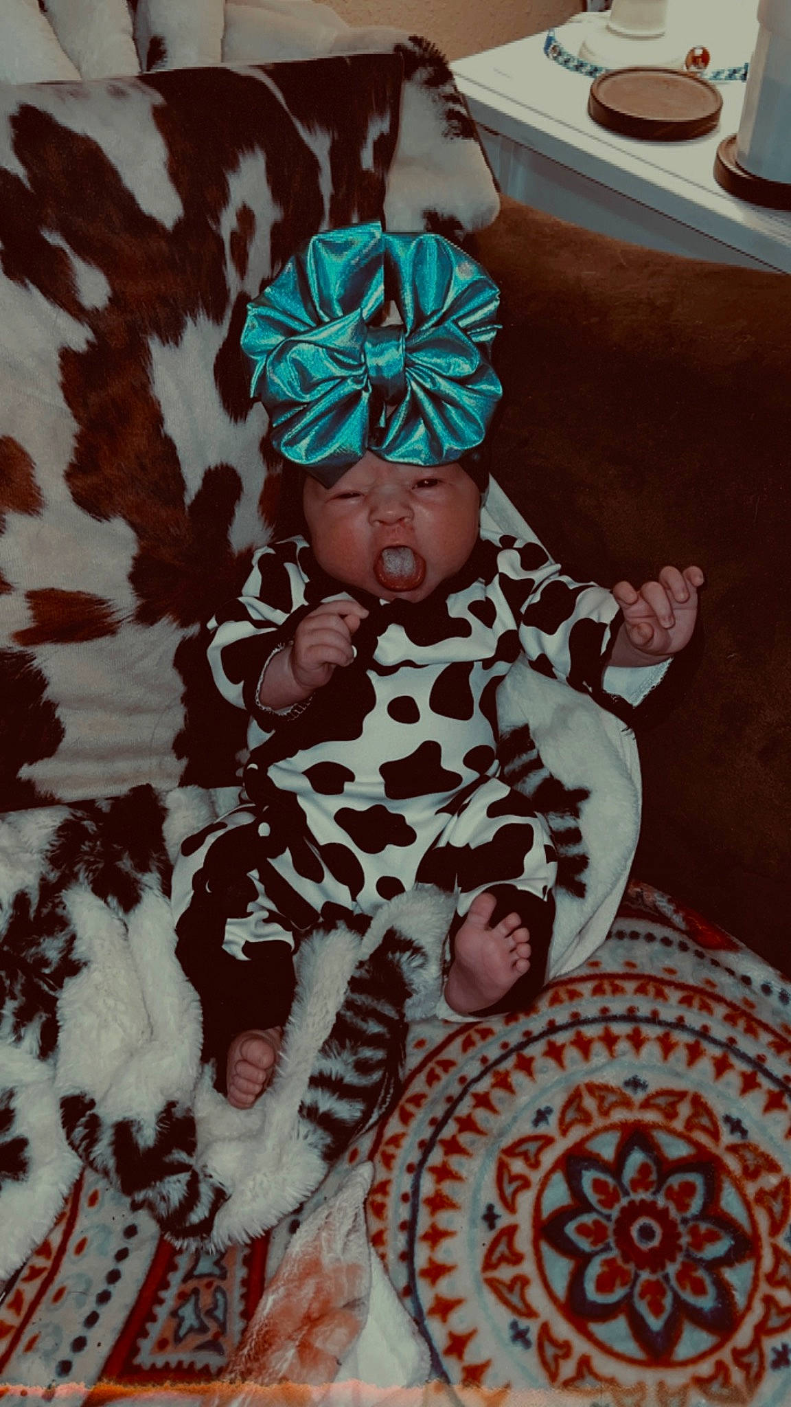 Kinslee is registered to the contest to win money with this photo: art, baby, beanie, cap, child, costume_hat, event, fashion_accessory, fictional_character, flooring, fun, fur, headgear, headwear, human_body, linens, pattern, person, personal_protective_equipment, sitting