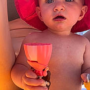 Aylé participe au concours pour gagner de l'argent avec cette photo : baby, bare_chest, blue_eyes, child, closeup, cute, diaper, expression, face, hand, infant, outdoor, person, play, red_hat, skin, summer, sunhat, sunlight, toy