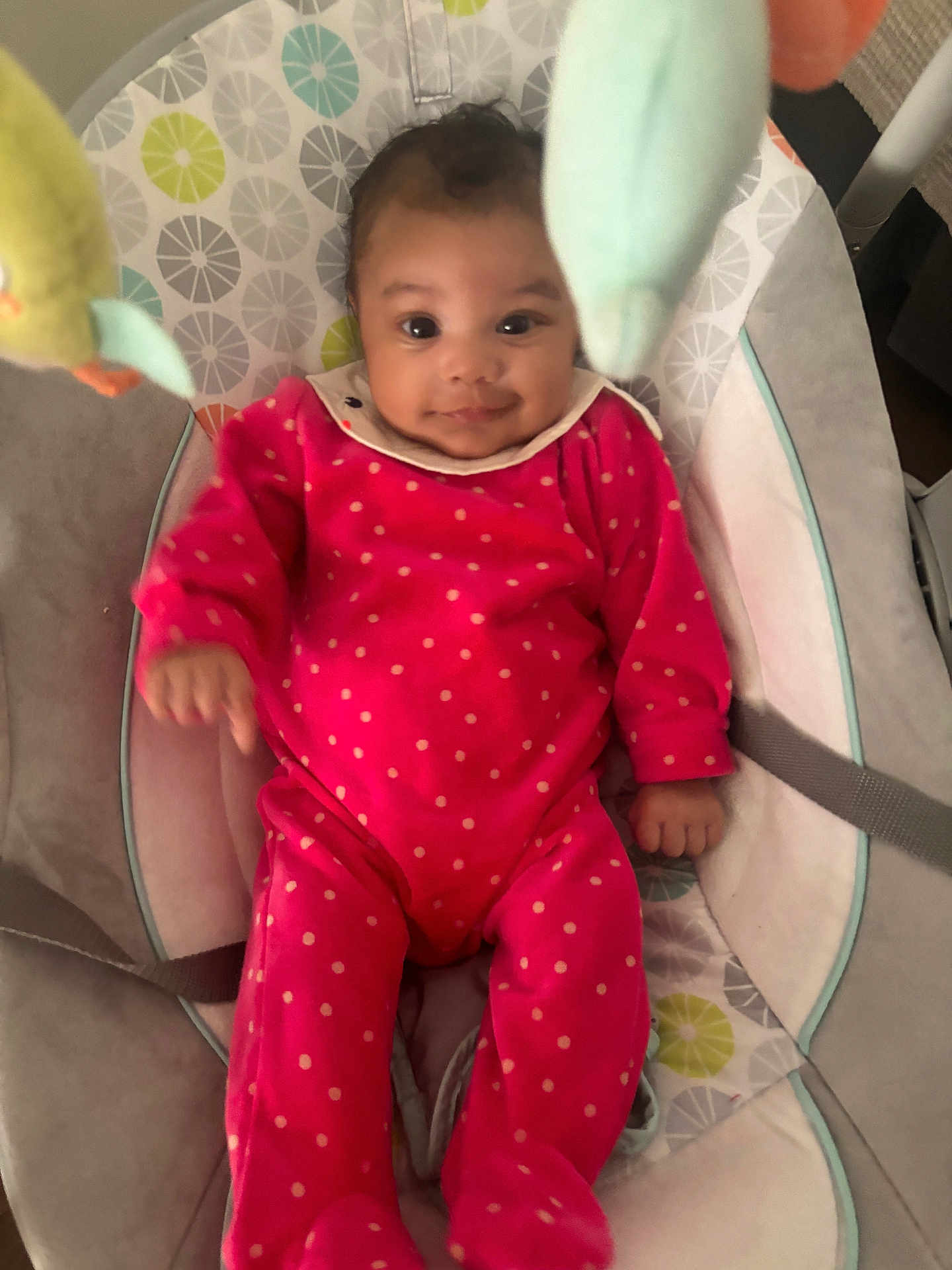 Rosalia participe au concours pour gagner de l'argent avec cette photo : baby, infant, red_onesie, polka_dot, baby_seat, cushion, toy, soft_toy, face, smile, indoor, child, person, cute, happy, eyes, clothing, seat_belt, baby_girl, comfort