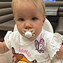 Mia a rejoint le concours — aidez-le/la à gagner de superbes lots ! toddler, pacifier, child, high_chair, indoor, shirt, cartoon, bambi, butterfly, earring, blond_hair, face, person, baby, cute, sitting, expressionless, clothing, room, television