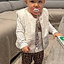 toddler, child, pacifier, headband, vest, leggings, boots, living_room, sofa, table, book, carpet, toy, clothing, person, face, indoor, cute, fashion, baby