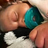 baby, pacifier, sleeping, close_up, blanket, soft_texture, infant, hand, resting, cozy, indoors, child, face, skin, comfort, peaceful, toddler, lying_down, young_child, nap