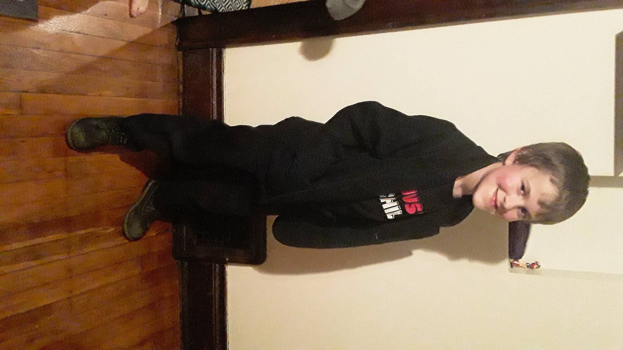 Tanner is registered to the contest to win money with this photo: balance, cleanliness, clock, comfort, elbow, flooring, hardwood, human_leg, joy, knee, person, room, sleeve, smile, sock, t_shirt, thigh, walking_shoe, wrist