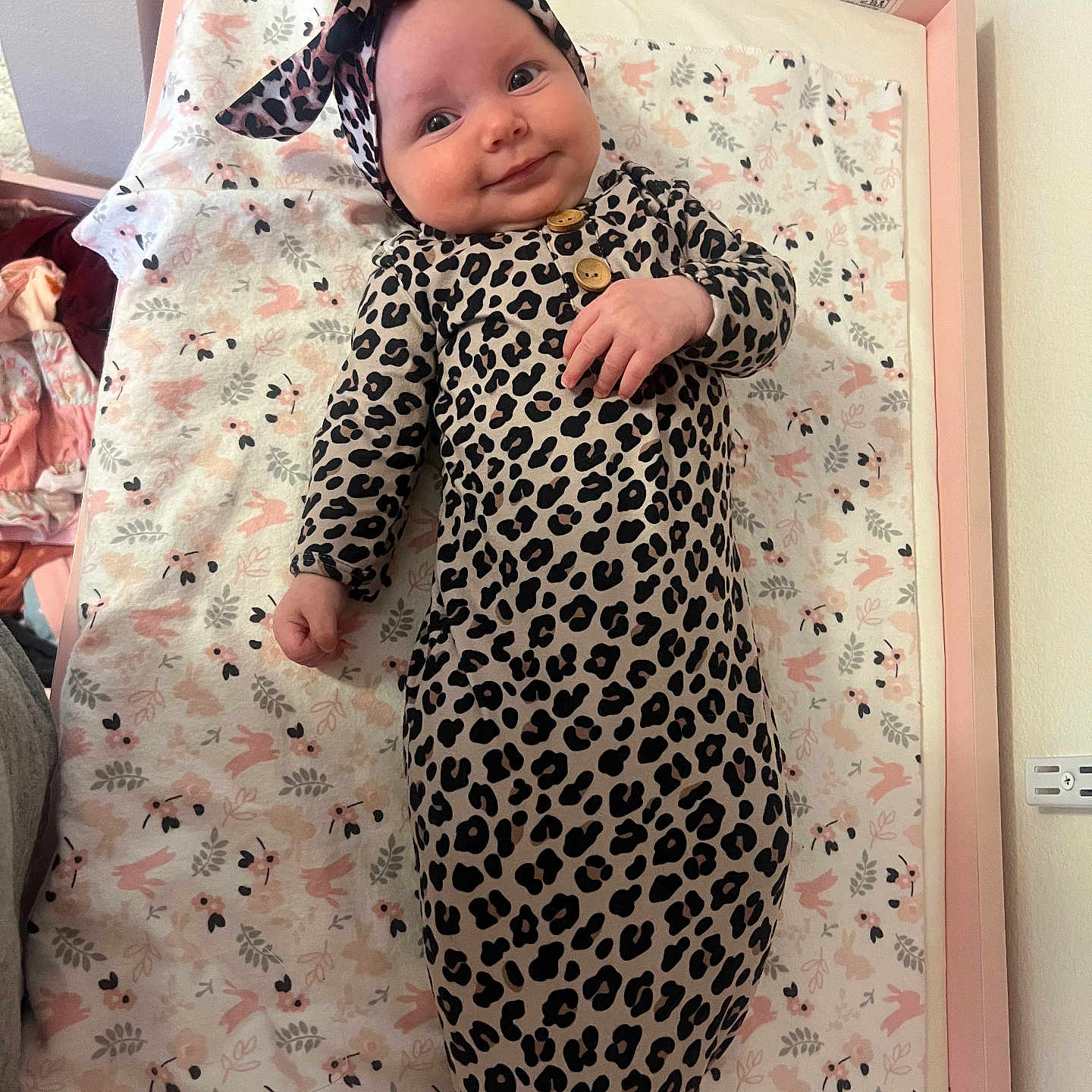 Nyla joined the competition — help win amazing prizes! baby, blanket, changing_pad, child, clothing, cute, floral, happy, headband, indoors, infant, leopard_print, lying_down, newborn, pattern, person, pink, smiling, soft, wooden_frame