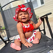 Zalayah Maelyn is registered to the contest to win money with this photo: baby, chair, child, clothing, cute, dimple, face, foot, hand, happy, hat, mesh, outdoor, person, portrait, red, smiling, summer, sunlight, white
