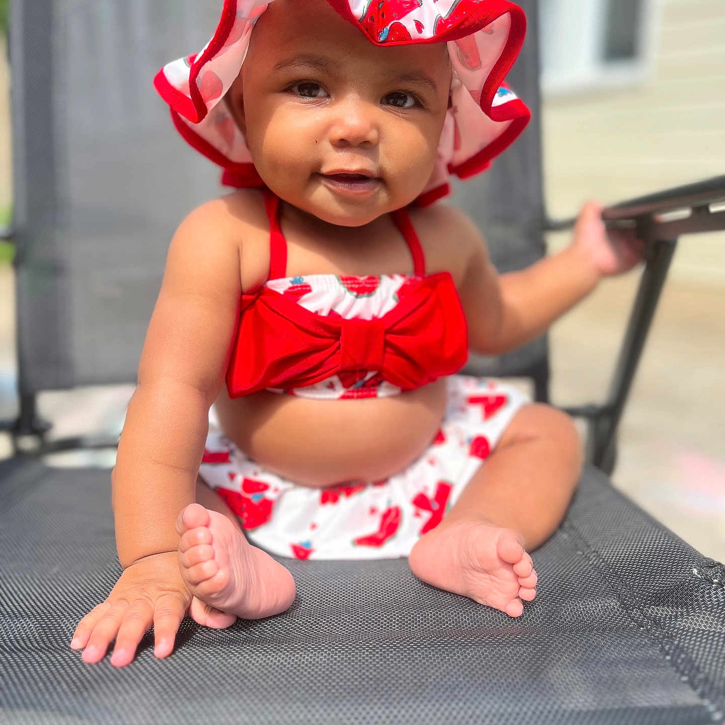 Zalayah Maelyn joined the competition — help win amazing prizes! baby, child, cute, daylight, foot, hand, happy, infant, mesh_chair, outdoor, playful, portrait, red_bow, sitting, skin, smiling, strawberry_pattern, summer, sunhat, sunlight