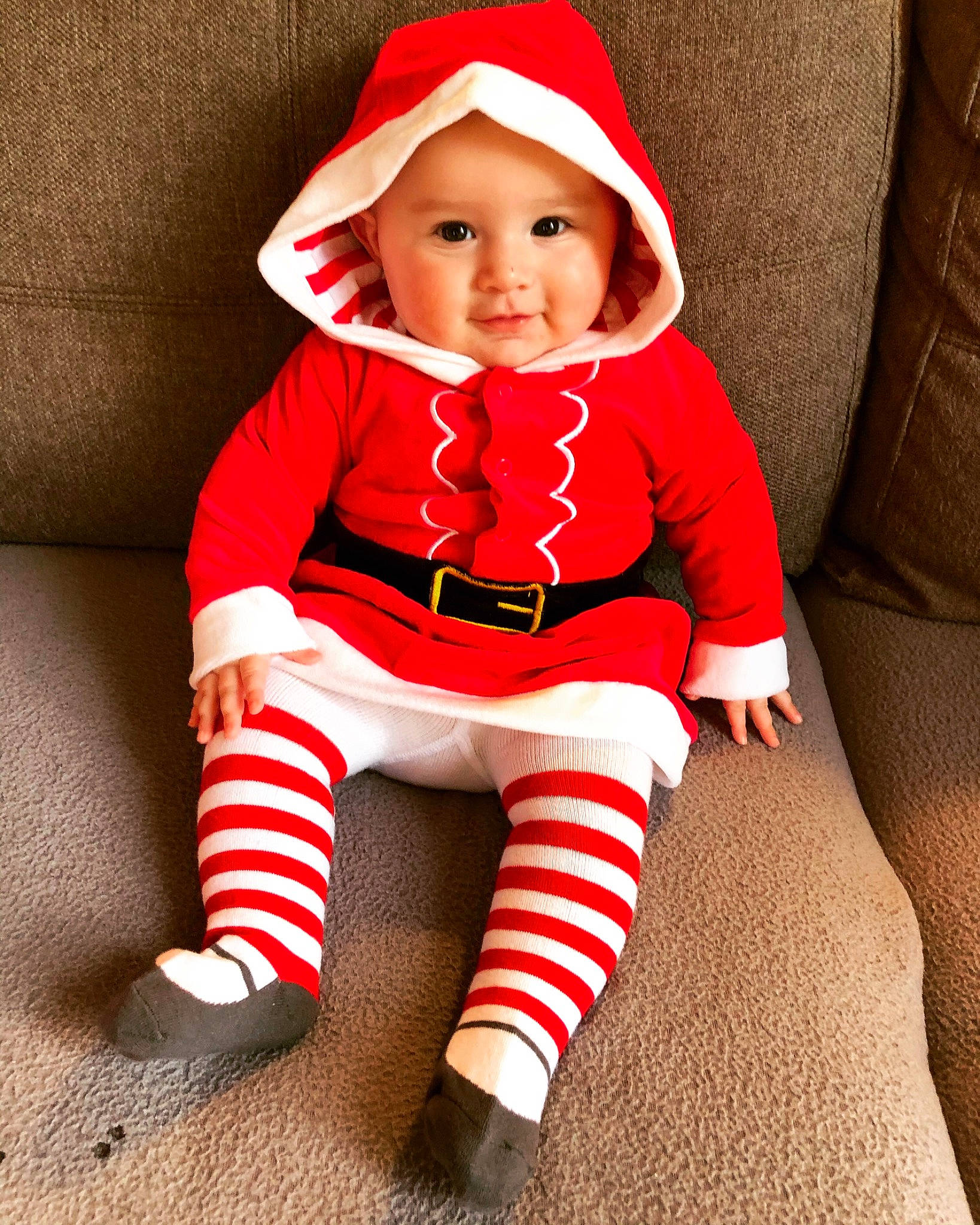 Cataleya participe au concours pour gagner de l'argent avec cette photo : baby, baby_toddler_clothing, carmine, cheek, child, christmas, comfort, costume_accessory, costume_hat, couch, fictional_character, foot, headwear, human_body, living_room, person, photo_shoot, red, sitting, sleeve