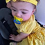 baby, pacifier, yellow_clothing, headband, stroller, infant, child, curious, cute, portrait, indoors, hand, face, leg, sock, fabric, person, toddler, soft_lighting, closeup