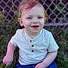 toddler, child, smiling, blue_eyes, sitting, grass, outdoor, casual_clothing, jeans, short_sleeve, fence, happy, young_child, portrait, daylight, nature, cute, baby, person, casual