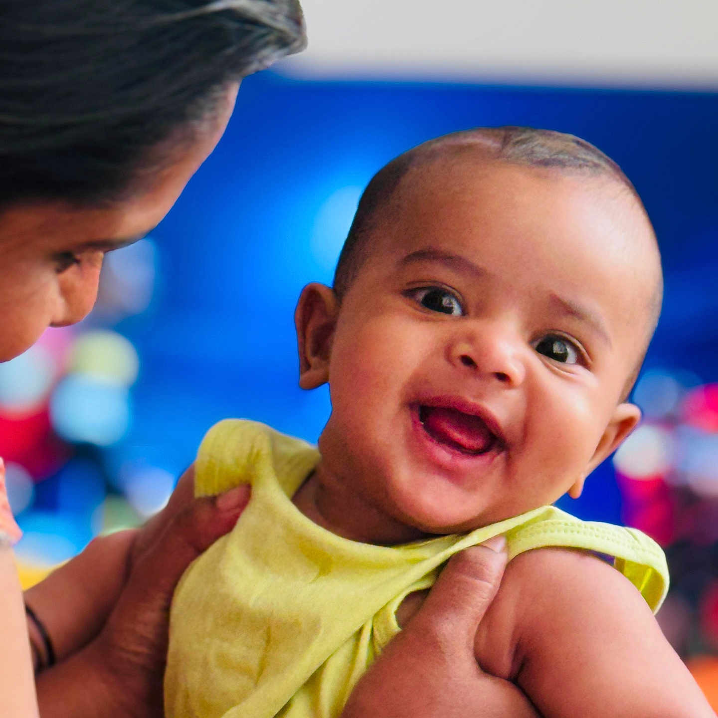 Darshit is registered to the contest to win money with this photo: adult, baby, child, closeup, cute, expression, face, family, hand, happy, head, holding, indoor, infant, love, person, portrait, skin, smiling, yellow_clothing