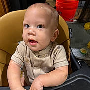 Elijah joined the competition — help win amazing prizes! baby, child, infant, high_chair, sitting, portrait, face, eyes, smiling, indoor, home, kitchen, baby_clothing, short_sleeves, hands, red_bucket, dining, furniture, photography, cute