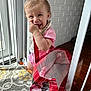 Lainee is registered to the contest to win money with this photo: baby, baby_gate, bag, brick_wall, carpet, cheeky, child, cute, hand_in_mouth, happy, home, indoor, pink_clothing, playful, portrait, smiling, sunlight, toddler, white_wall, wooden_floor