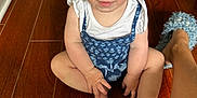 Lainee joined the competition — help win amazing prizes! baby, barefoot, blue_clothing, child, cute, face, floor, hands, home, indoor, legs, looking_up, person, portrait, romper, sitting, skin, slippers, toes, wooden_floor